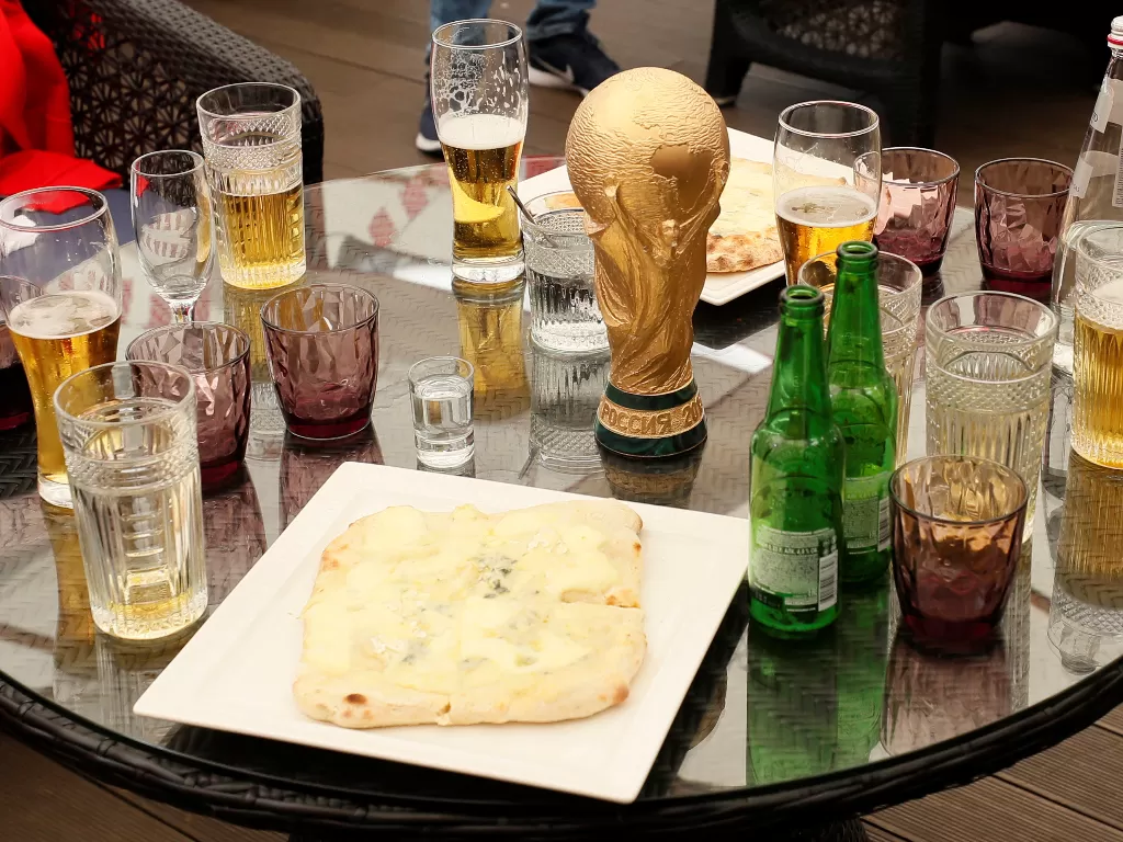 Replika trofi Piala Dunia dan gelas-gelas berisi minuman alkohol di restoran saat Piala Dunia 2018 di Rusia. (REUTERS/Glab Garanich)