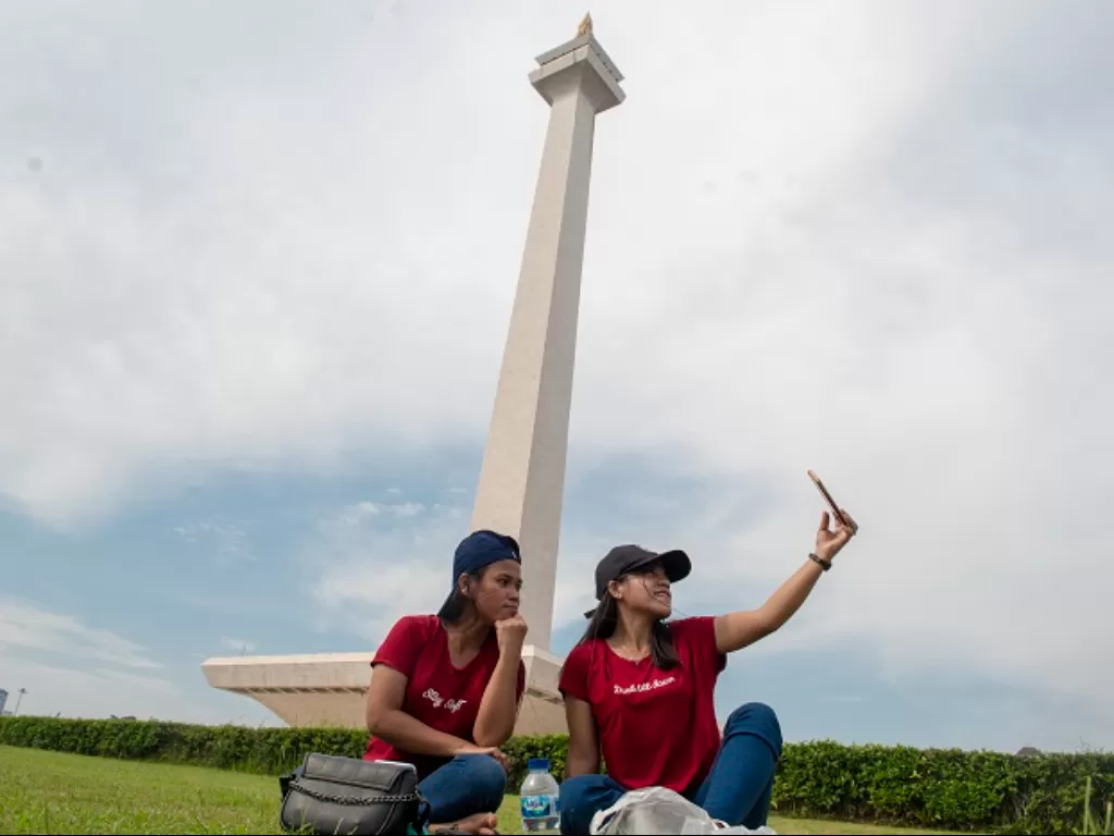 Warga berswafoto di kawasan Monumen Nasional (Monas), Jakarta. (ANTARA FOTO/Muhammad Adimaja)