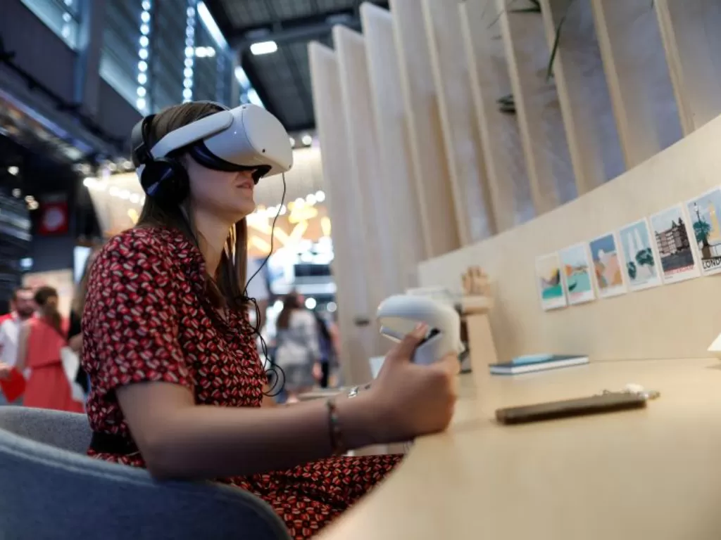 Seorang pengguna mengenakan headset virtual reality (VR) mencoba aplikasi VR di stan Meta Platforms Inc. pada konferensi Viva Technology yang didedikasikan untuk inovasi dan startup di pusat pameran Porte de Versailles di Paris, Prancis 16 Juni 2022. (REU