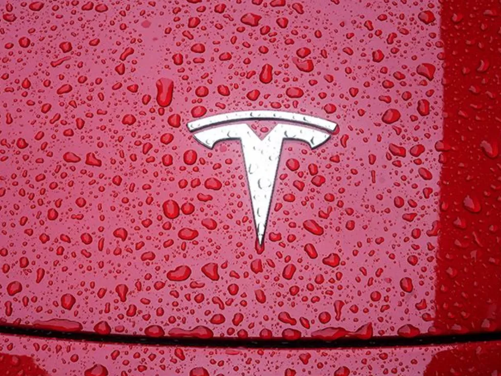 Logo Tesla terlihat di sebuah mobil di tengah hujan di wilayah Manhattan, New York City, New York, AS, Rabu (5/5/2021). (ANTARA/REUTERS/Carlo Allegri/am)