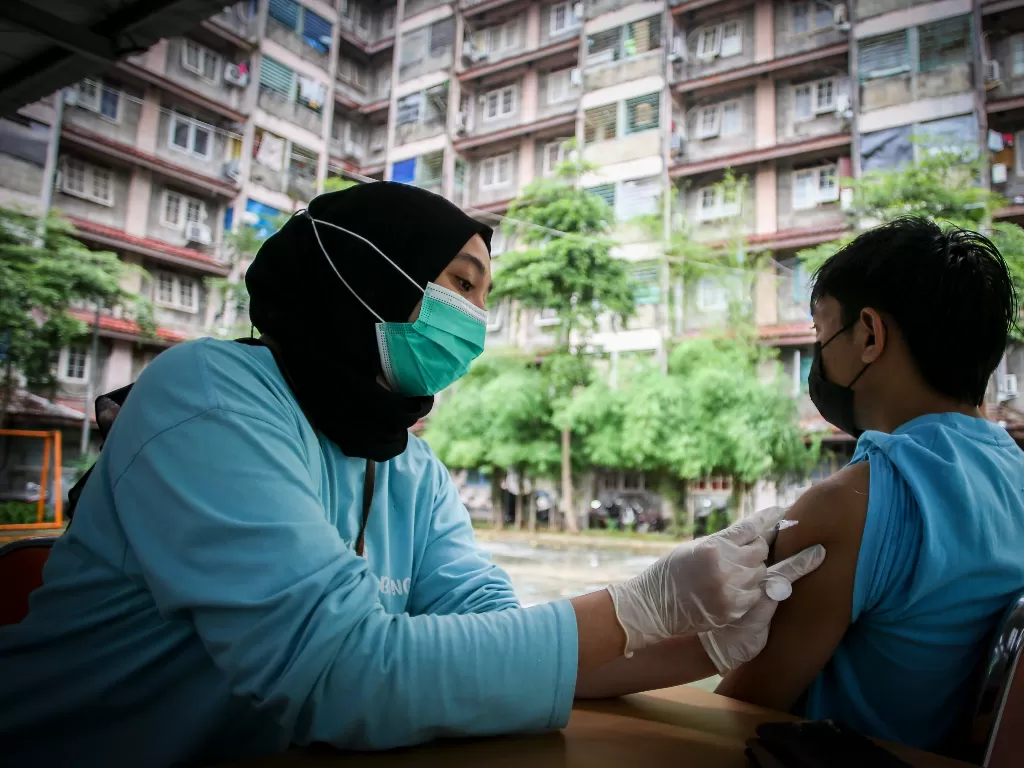 Petugas menyuntikkan vaksin COVID-19 dosis ketiga kepada warga di RPTRA Rusun Benhil, Jakarta, Rabu (6/7/2022). (ANTARA FOTO/Rivan Awal Lingga/YU)
