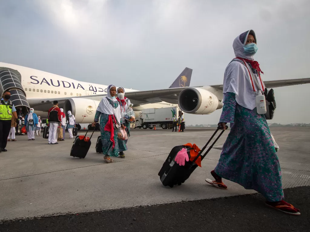 Jamaah haji yang tergabung dalam kelompok terbang (kloter) pertama tiba Terminal 2 Bandara Internasional Juanda Surabaya di Sidoarjo, Jawa Timur, Minggu (17/7/2022). (ANTARA FOTO/Umarul Faruq)