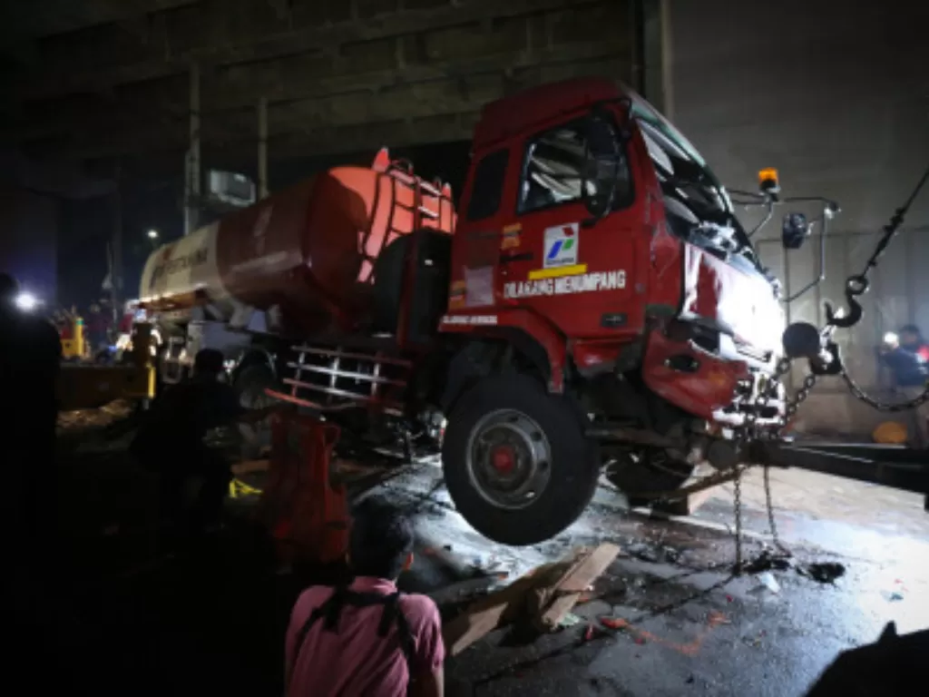 Petugas menggunakan mobil derek untuk mengangkat kepala truk pengangkut BBM yang mengalami kecelakaan maut di Cibubur. (ANTARA FOTO/Asprilla Dwi Adha)