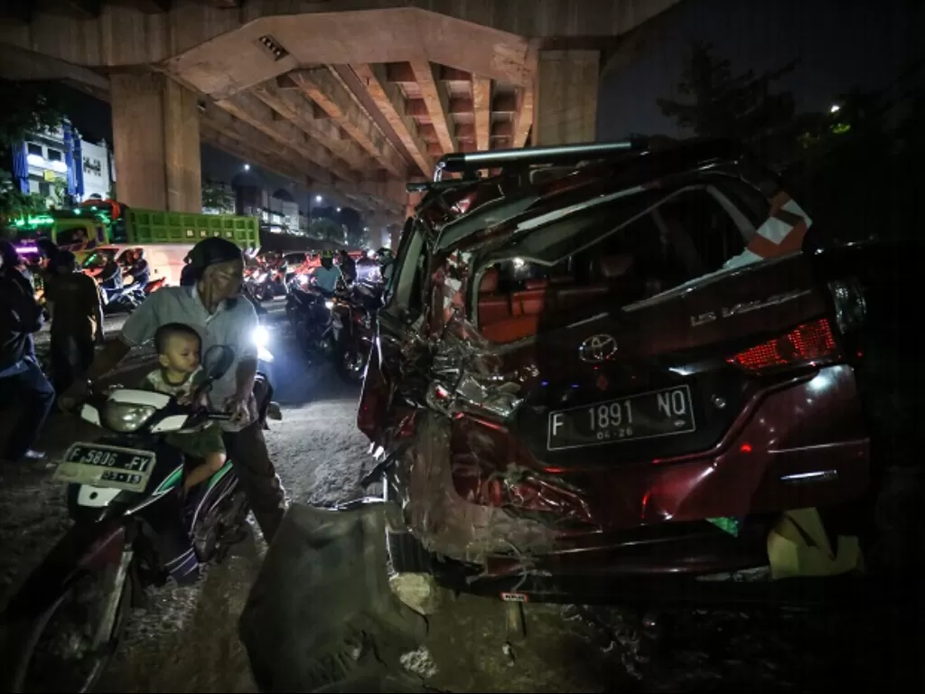 Sejumlah warga melihat kendaraan yang mengalami kerusakan akibat kecelakaan di Jalan Transyogi, Cibubur, Bekasi. (ANTARA FOTO/Asprilla Dwi Adha)