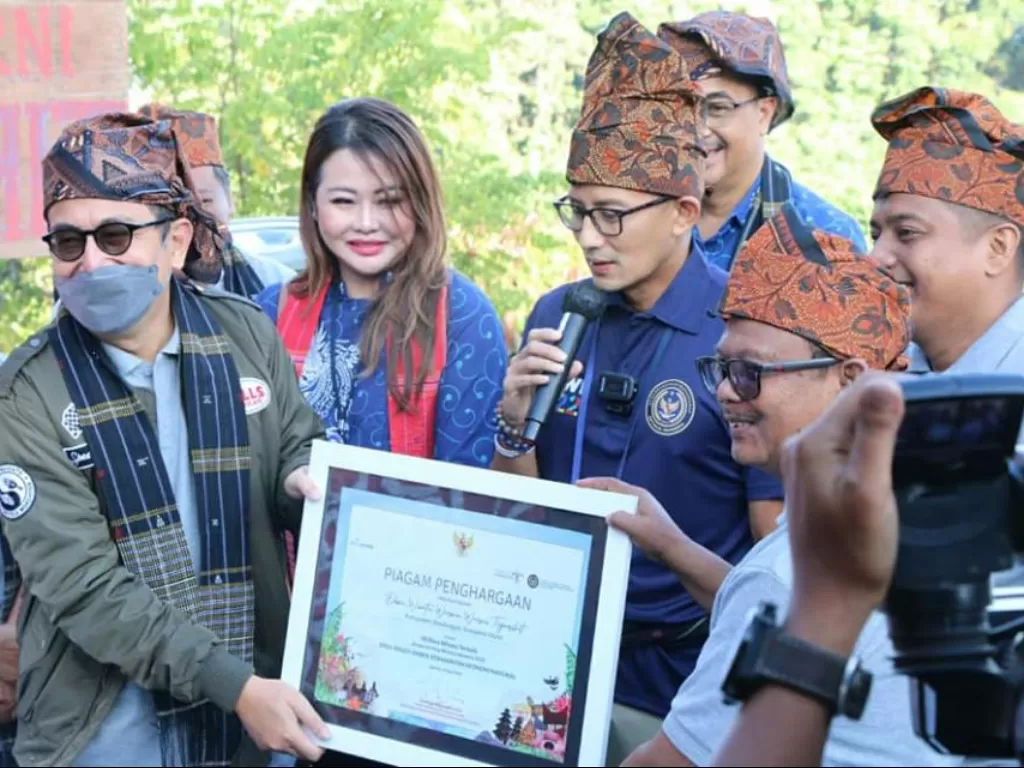 Sandiaga Uno menyerahkan piagam Desa Wisata Warna Warni Tigarihit Kabupaten Simalungun sebagai 50 Desa Wisata Terbaik. (Foto/Istimewa)