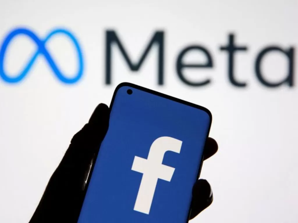 Sebuah smartphone dengan logo Facebook terlihat di depan tampilan logo Meta. Ilustrasi ini diambil 28 Oktober 2021. (REUTERS/DADO RUVIC)