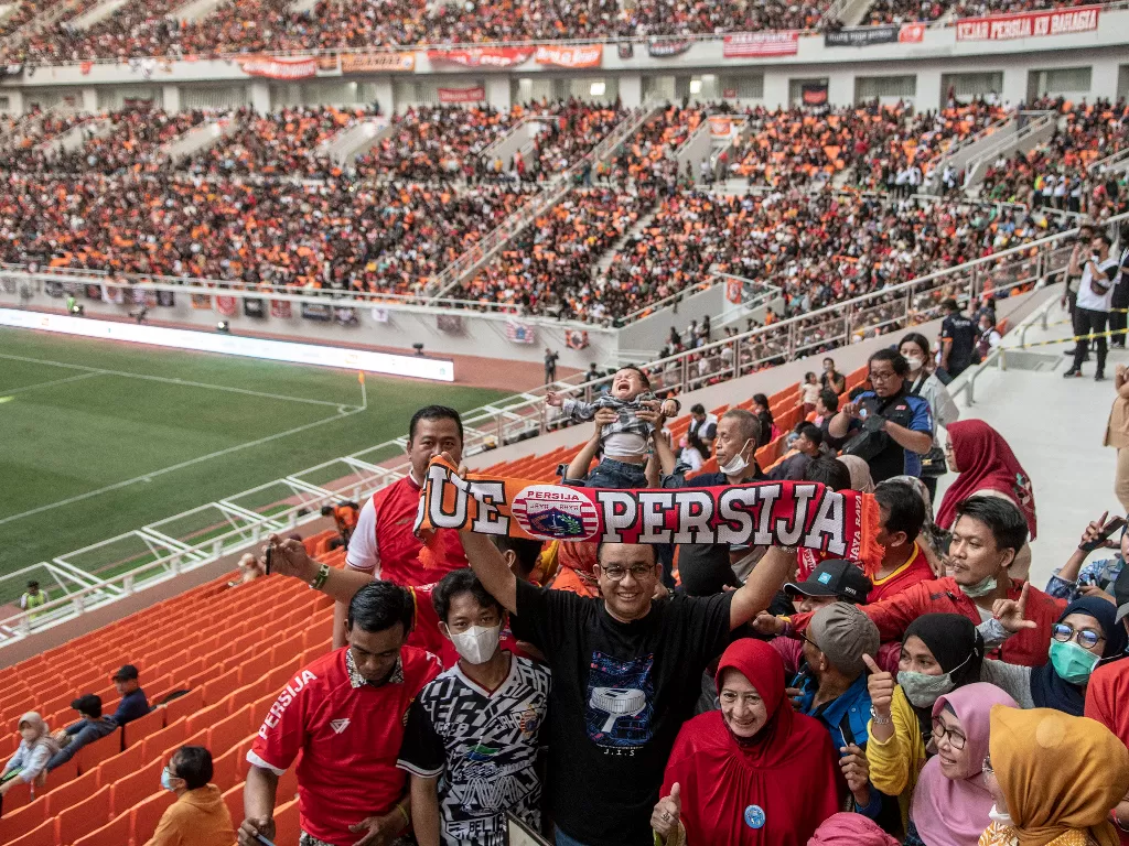 Gubernur DKI Jakarta Anies Baswedan membentangkan atribut Persija Jakarta saat menghadiri peresmian Stadion JIS di Jakarta, Minggu (24/7/2022). (ANTARA/Muhammad Adimaja)