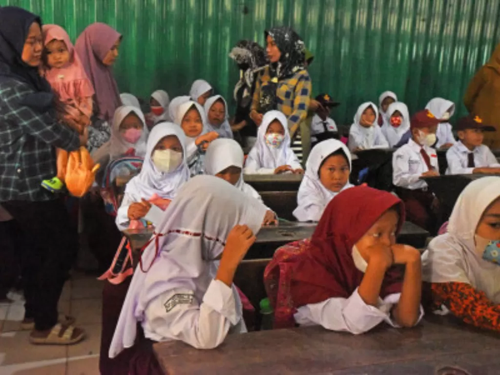 Sejumlah ibu rumah tangga menemani anaknya masuk sekolah pada hari pertama pembelajaran tatap muka (PTM) 100 persen di SD Negeri 07 Kota Serang, Banten (ANTARA FOTO/Asep Fathulrahman)