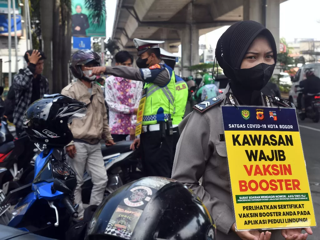 Personel Polresta Bogor Kota melakukan razia vaksinasi booster bagi pengendara motor di jalan KH Sholeh Iskandar, Kota Bogor, Jawa Barat, Kamis (28/7/2022). (ANTARA FOTO/Arif Firmansyah)
