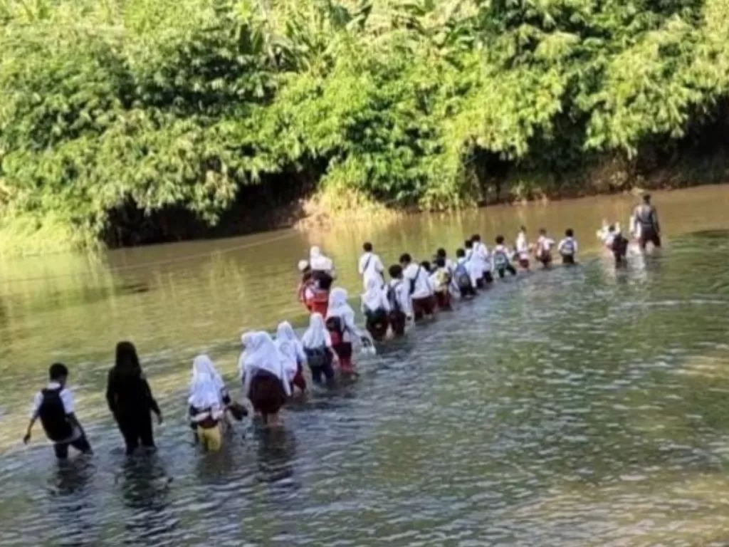 Setiap hari siswa di Desa Sukaluyu, Kecamatan Cikadu, Cianjur, Jawa Barat, terpaksa pergi dan pulang sekolah menyeberang sungai karena jembatan gantung putus. (ANTARA/Ahmad Fikri)