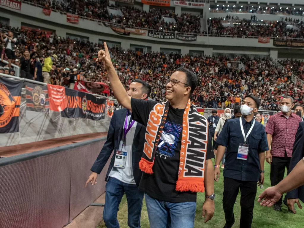 Gubernur DKI Jakarta Anies Baswedan membentangkan atribut Persija Jakarta saat menghadiri peresmian Stadion JIS di Jakarta. (ANTARA/Muhammad Adimaja)