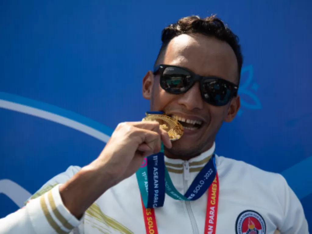 Perenang Indonesia Rino Saputra menunjukkan medali emas ASEAN Para Games 2022. (ANTARA FOTO/Aji Styawan)