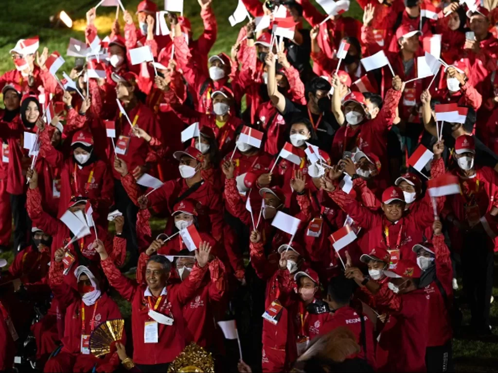 Kontingen Indonesia berjalan sambil membawa bendera dan melambaikan tangan pada penutupan ASEAN Para Games 2022 di Stadion Manahan, Solo, Jawa Tengah. (ANTARA FOTO/Hendra Nurdiyansyah)