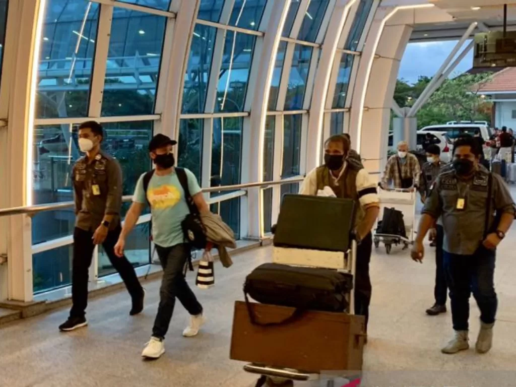 Petugas Imigrasi mendampingi tiga WNA berkebangsaan Belanda, Jerman, dan Rusia dideportasi kembali ke negaranya melalui Bandara Internasional I Gusti Ngurah Rai, Bali, Selasa (9-9-2022). (Dok. Kanwil Kemenkumham Bali)
