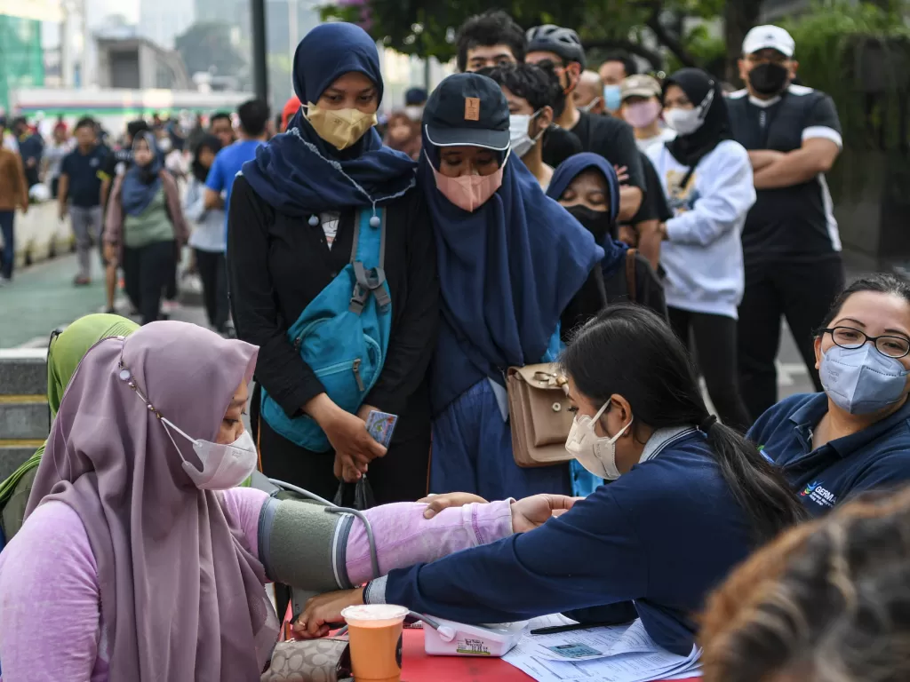 Petugas kesehatan memeriksa tekanan darah (tensi) dari warga sebelum mengikuti vaksinasi COVID-19 saat Car Free Day atau Hari Bebas Kendaraan Bermotor di kawasan MH Thamrin, Jakarta, Minggu (31/7/2022). (ANTARA/M Risyal Hidayat)