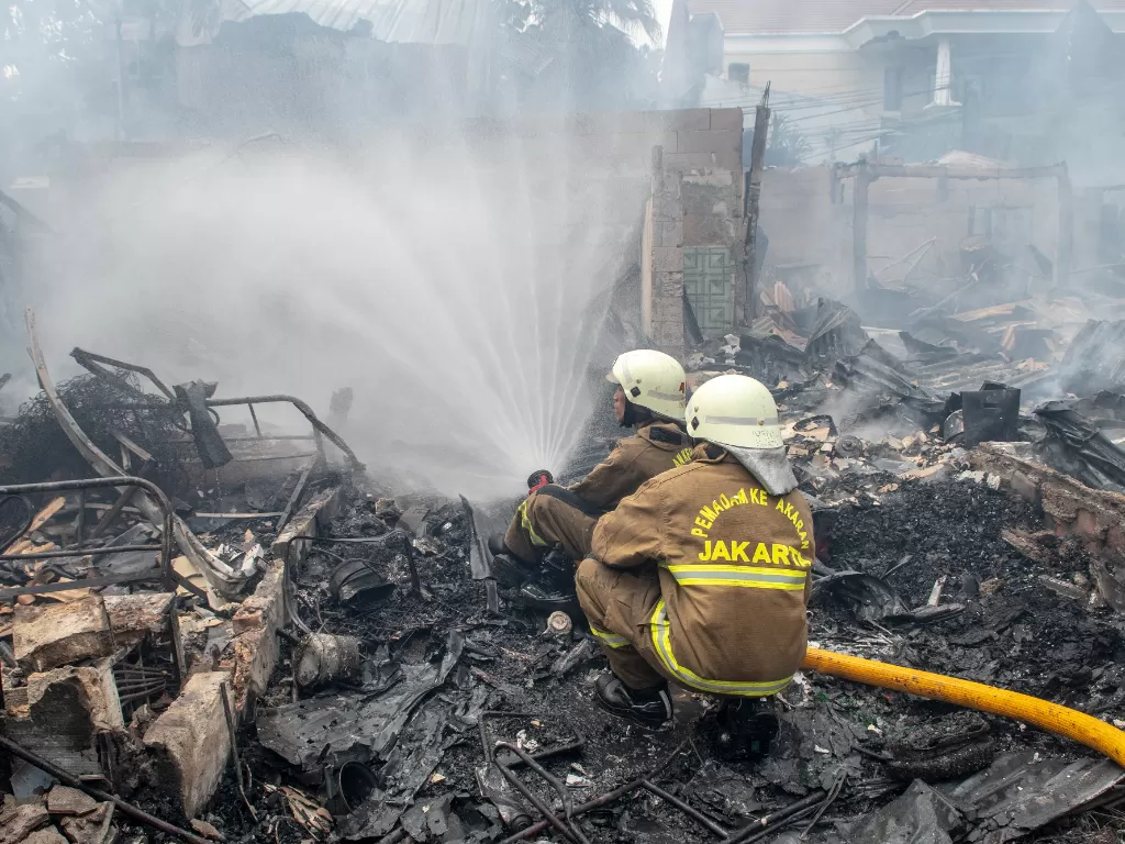 Petugas pemadam kebakaran memadamkan api yang membakar rumah penduduk di kawasan Jalan Simprug Golf Dua, Jakarta, Minggu (21/8/2022). (ANTARA FOTO/Muhammad Adimaja)