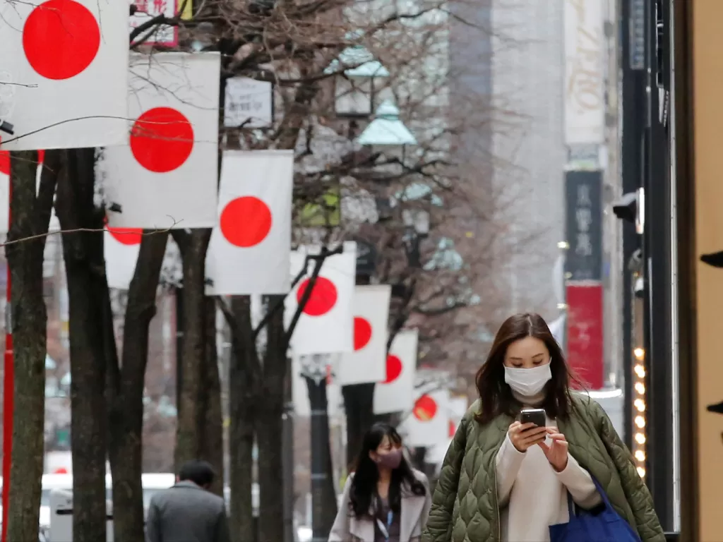 Ilustrasi seorang warga menggunakan HP jalan di salah satu kota di Jepang. (Dok. REUTERS)