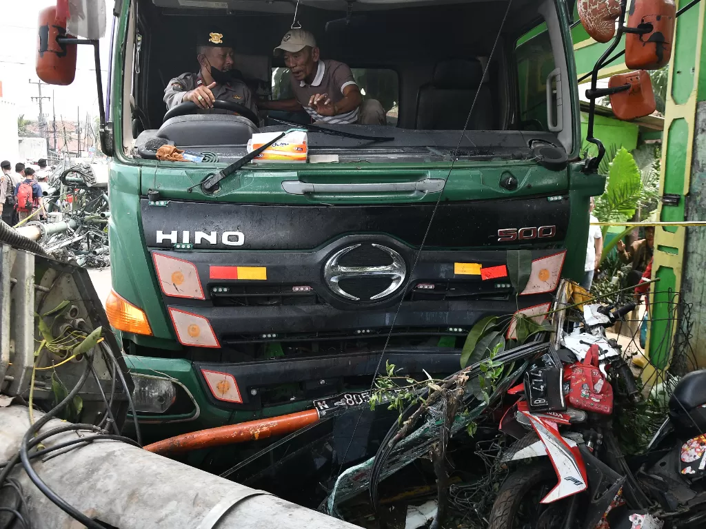 Petugas Kepolisian berusaha mengevakuasi sebuah truk kontainer yang menabrak halte bus di depan SDN Kota Baru II dan III di Jalan Sultan Agung, Bekasi, Jawa Barat, Rabu (31/8/2022). (ANTARA/Fakhri Hermansyah)