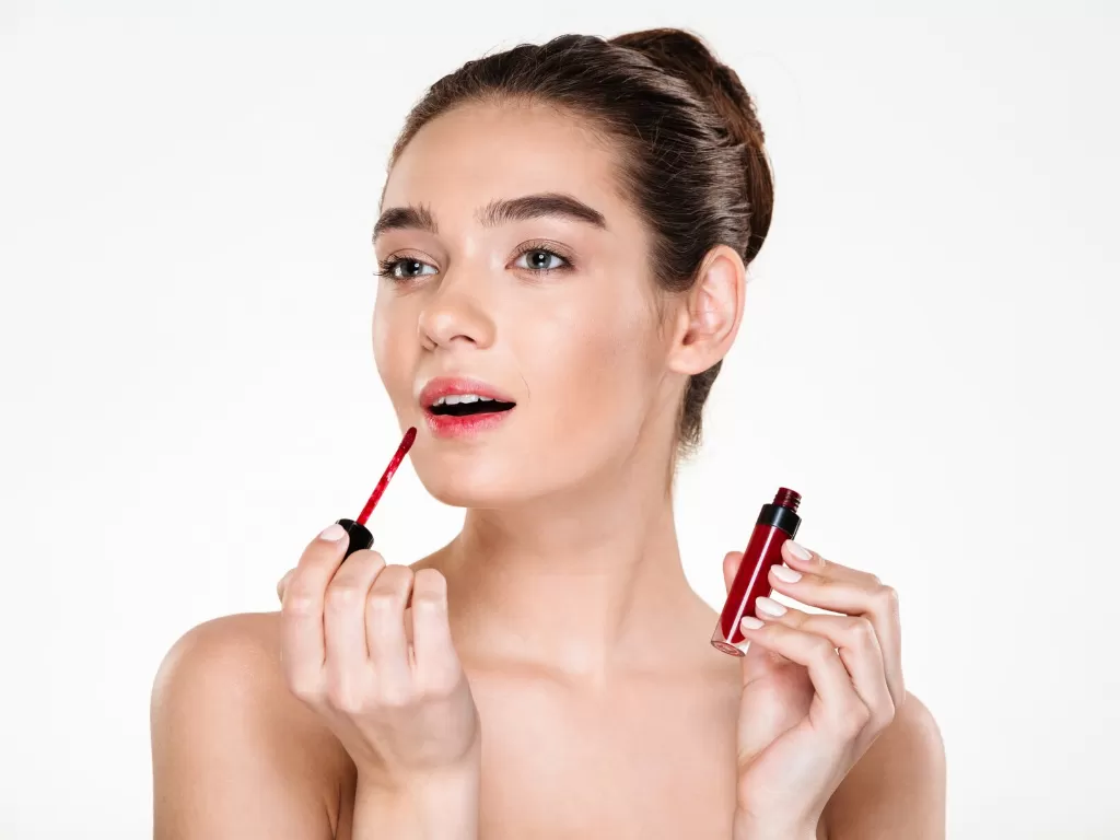 Ilustrasi wanita menggunakan lip gloss (Freepik)