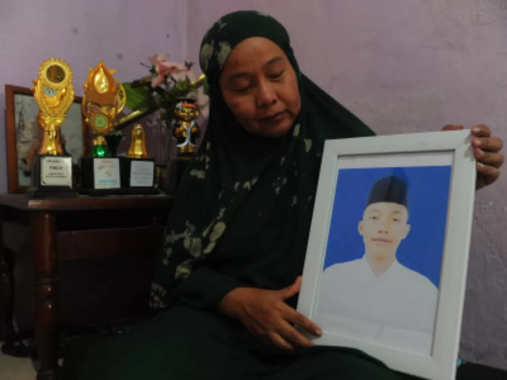 Orang tua AM santri Pondok Modern Darussalam Gontor 1 menunjukkan foto putranya yang meninggal. (ANTARA FOTO/Feny Selly)