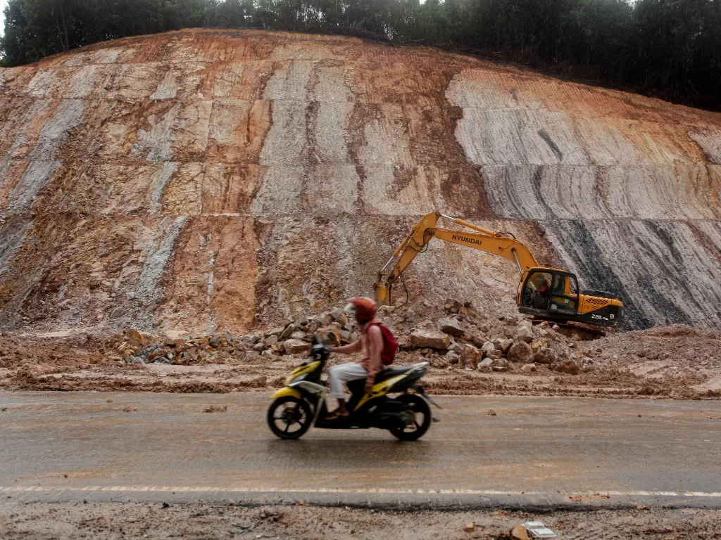 (Ilustrasi) Pengendara sepeda motor melintas di dekat proyek pembangunan jalan penghubung sejumlah kawasan industri di Batam, Kepulauan Riau, Jumat (9/9/2022). (ANTARA FOTO/Teguh Prihatna)