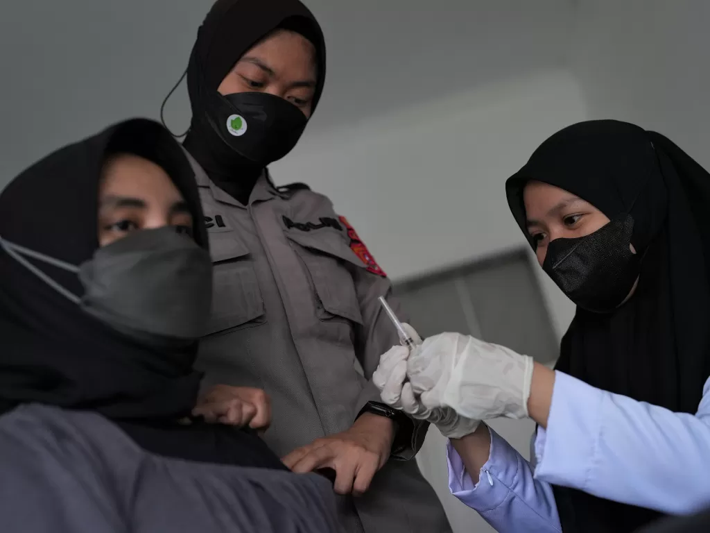 Petugas medis bidang Dokkes Polri memberikan vaksinasi COVID-19 ke tenaga kesehatan di Polresta Kendari, Kendari, Sulawesi Tenggara, Rabu (14/9/2022). (ANTARA/Jojon)