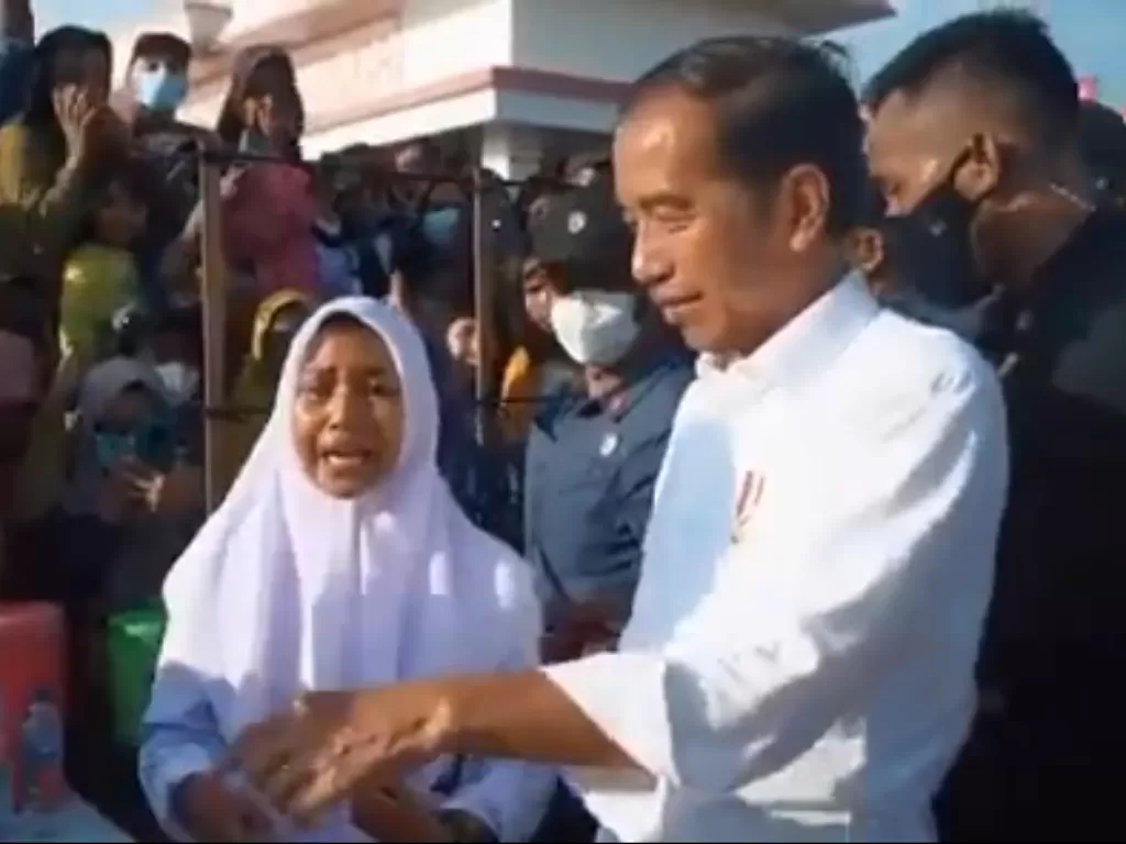 Seorang siswi yang HP-nya rusak saat menunggu kedatangan Presiden Jokowi. (Instagram/@pramonoanungw)
