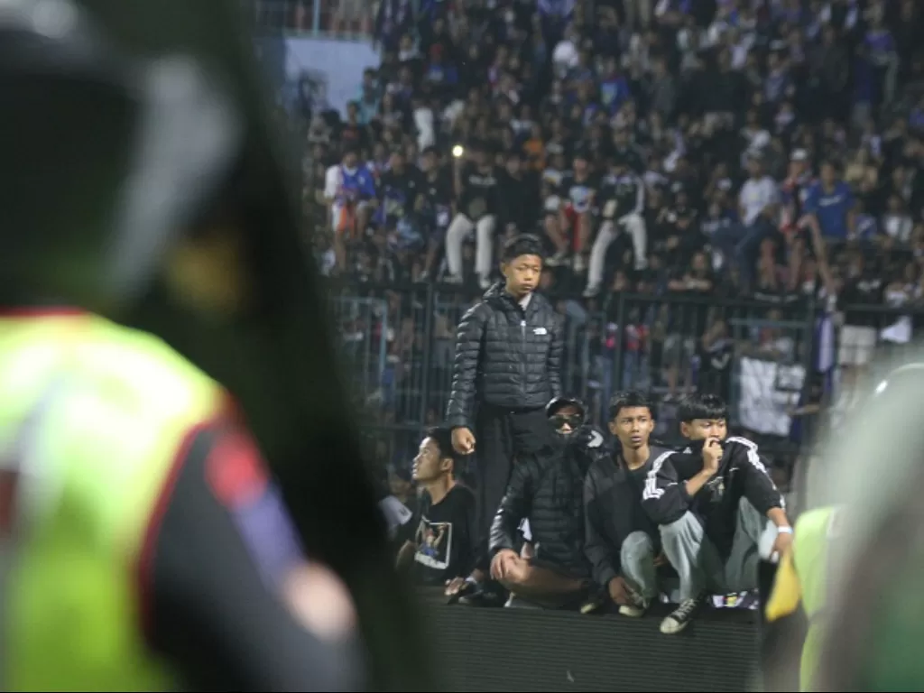 Aparat keamanan berusaha menghalau suporter yang masuk ke lapangan usai pertandingan Liga 1 antara Arema vs Persebaya di Stadion Kanjuruhan. (ANTARA FOTO/Ari Bowo Sucipto)
