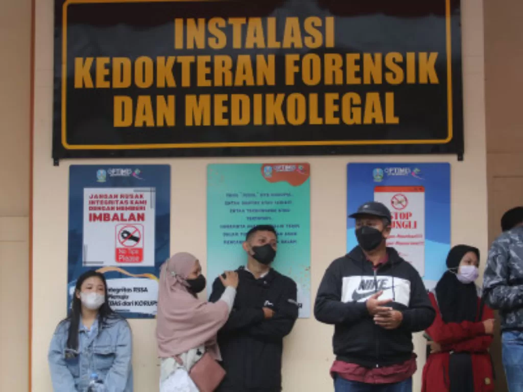 Perwakilan keluarga korban kerusuhan sepak bola menunggu hasil identifikasi di depan kamar jenazah Rumah Sakit Saiful Anwar, Malang, Jawa Timur, Minggu (2/10/2022). (ANTARA FOTO/Prasetia Fauzani)