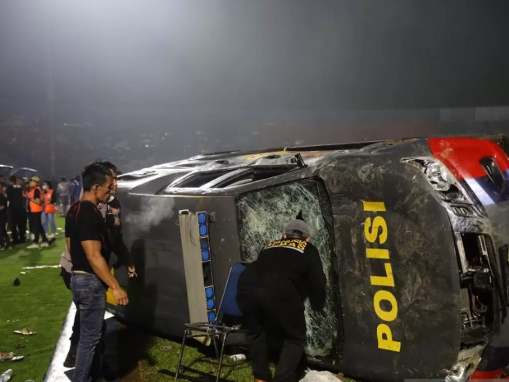 Sebuah mobil polisi terbalik akibat kericuhan usai pertandingan BRI Liga 1 antara Arema melawan Persebaya di Stadion Kanjuruhan, Malang, Jatim, Minggu (2/10/2022). (ANTARA/H Prabowo)