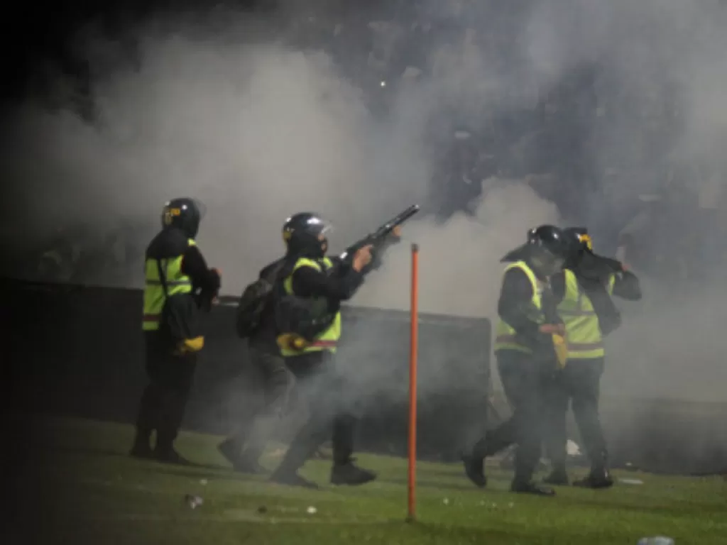 Aparat keamanan menembakkan gas air mata untuk menghalau suporter yang masuk ke lapangan usai pertandingan Arema vs Persebaya, Sabtu (1/10/2022) malam di Stadion Kanjuruhan Malang. (ANTARA FOTO/Ari Bowo Sucipto)
