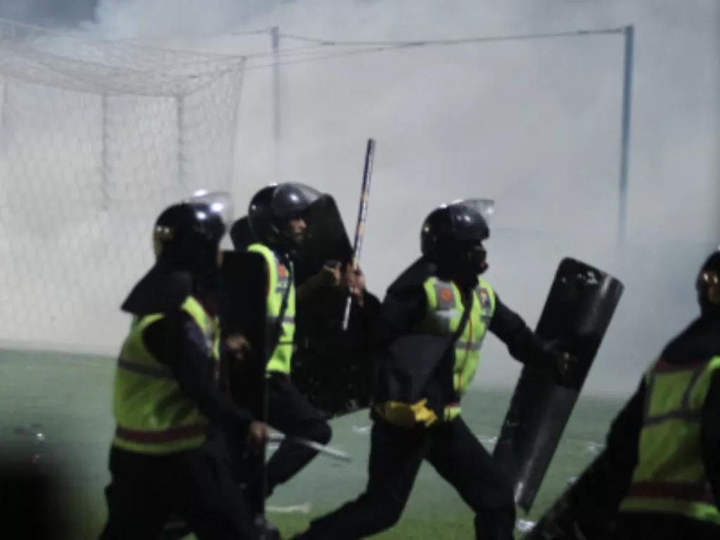 Aparat keamanan berusaha menghalau suporter yang masuk ke lapangan usai pertandingan Arema vs Persebaya di Stadion Kanjuruhan, Sabtu (1/10/2022). (ANTARA FOTO/Ari Bowo Sucipto)