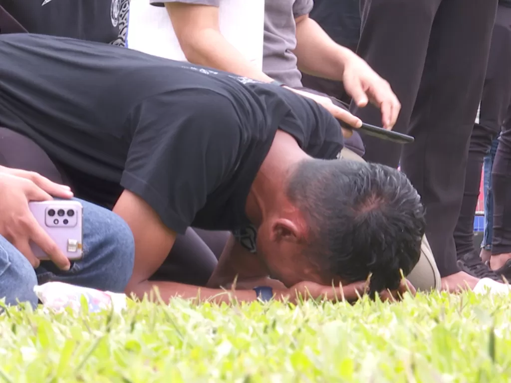 Pemain Arema FC menangis pilu saat tabur bunga di Stadion Kanjuruhan. (Z Creators/Tri Endang Suprihatin)