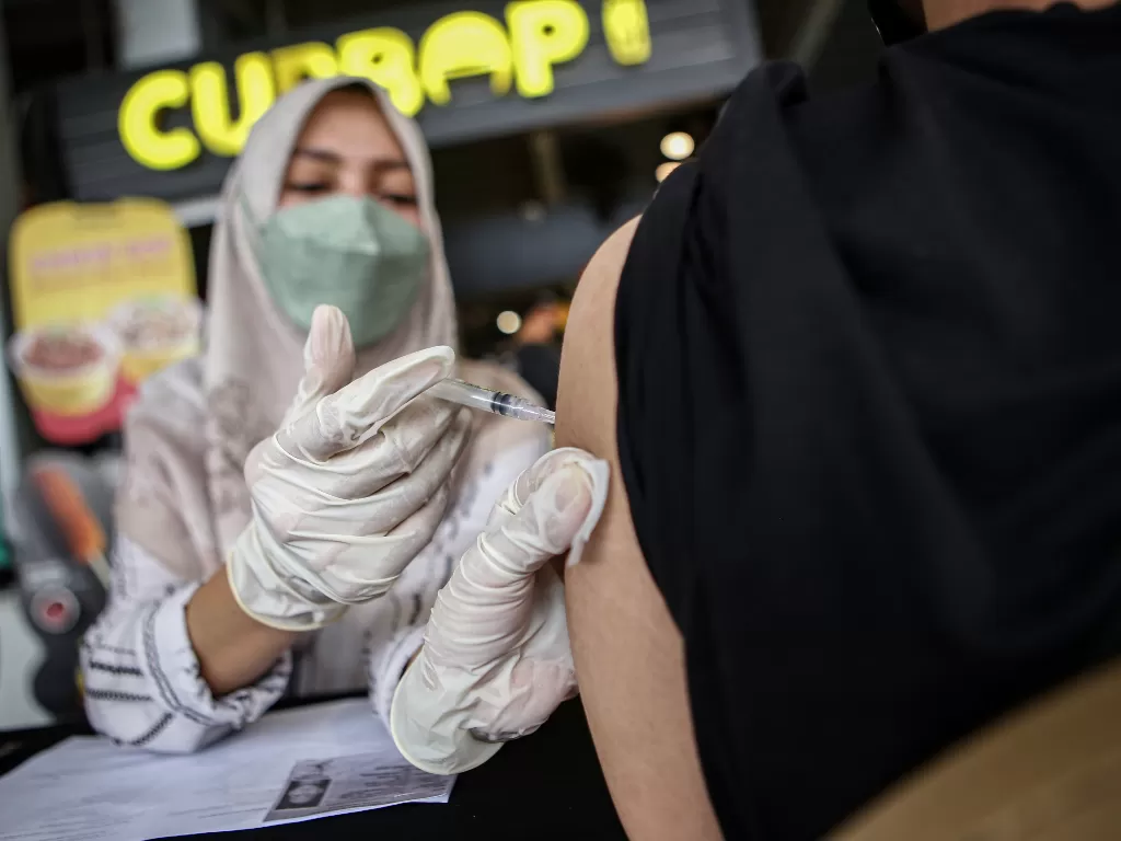 Petugas kesehatan menyuntikkan vaksin COVID-19 kepada warga. (ANTARA FOTO/Fauzan)