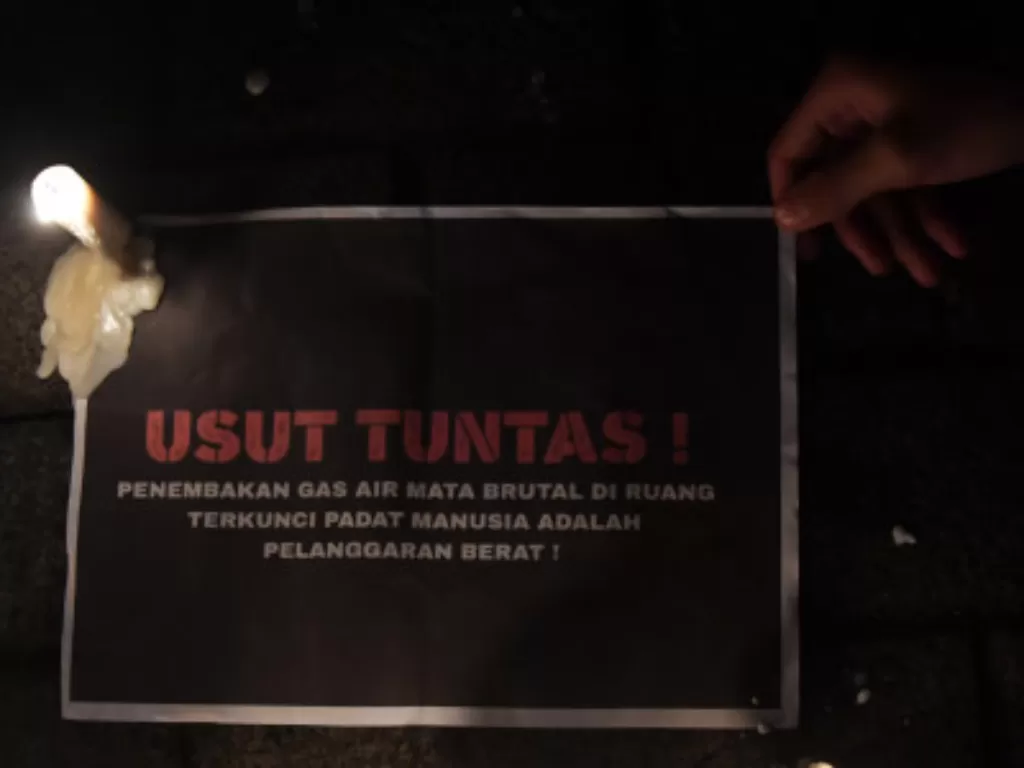 Suporter Arema FC (Aremania) meletakan poster ketika melakukan pertemuan di depan Stadion Gajyana, Kota Malang, Jawa Timur, Senin (3/10/2022) pasca tragedi Kanjuruhan. (ANTARA FOTO/Zabur Karuru)