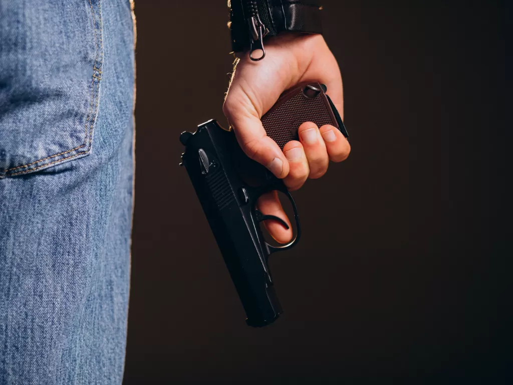 Ilustrasi pria memegang pistol. (Freepik/senivpetro)
