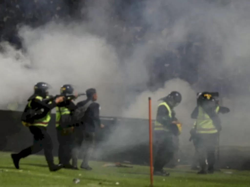Momen aparat kepolisian menembakan gas air mata saat tragedi Kanjuruhan pecah. (ANTARA FOTO/Ari Bowo Sucipto)