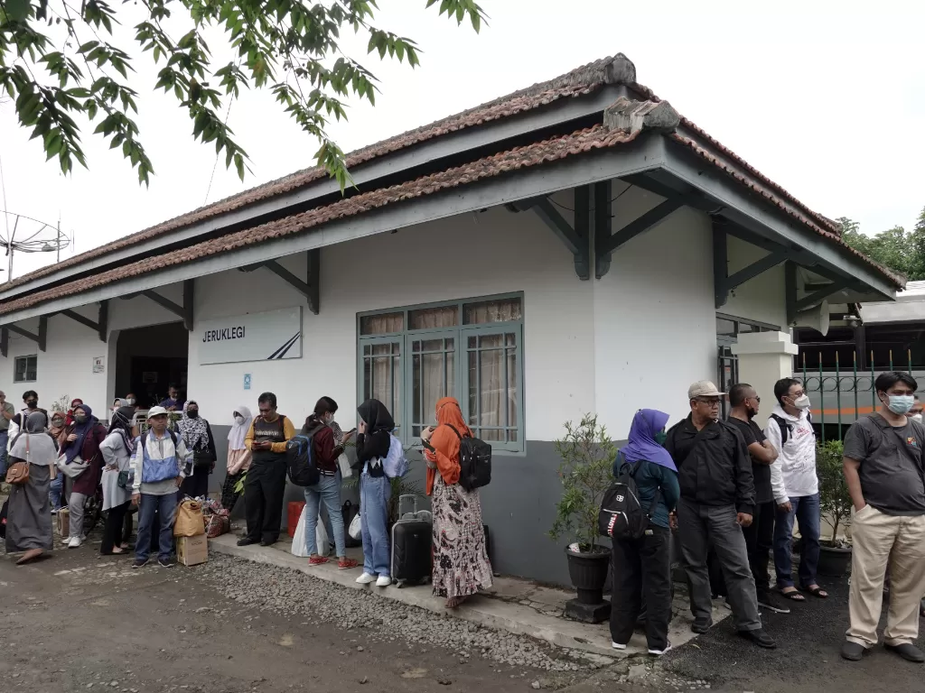 Penumpang KA Turangga jurusan Surabaya-Bandung menunggu armada bus untuk proses pemindahan, akibat gangguan perjalanan yang diakibatkan amblesnya rel di Stasiun Jeruklegi, Cilacap, Jateng, Sabtu (8/10/2022). (ANTARA/Idhad Zakaria)