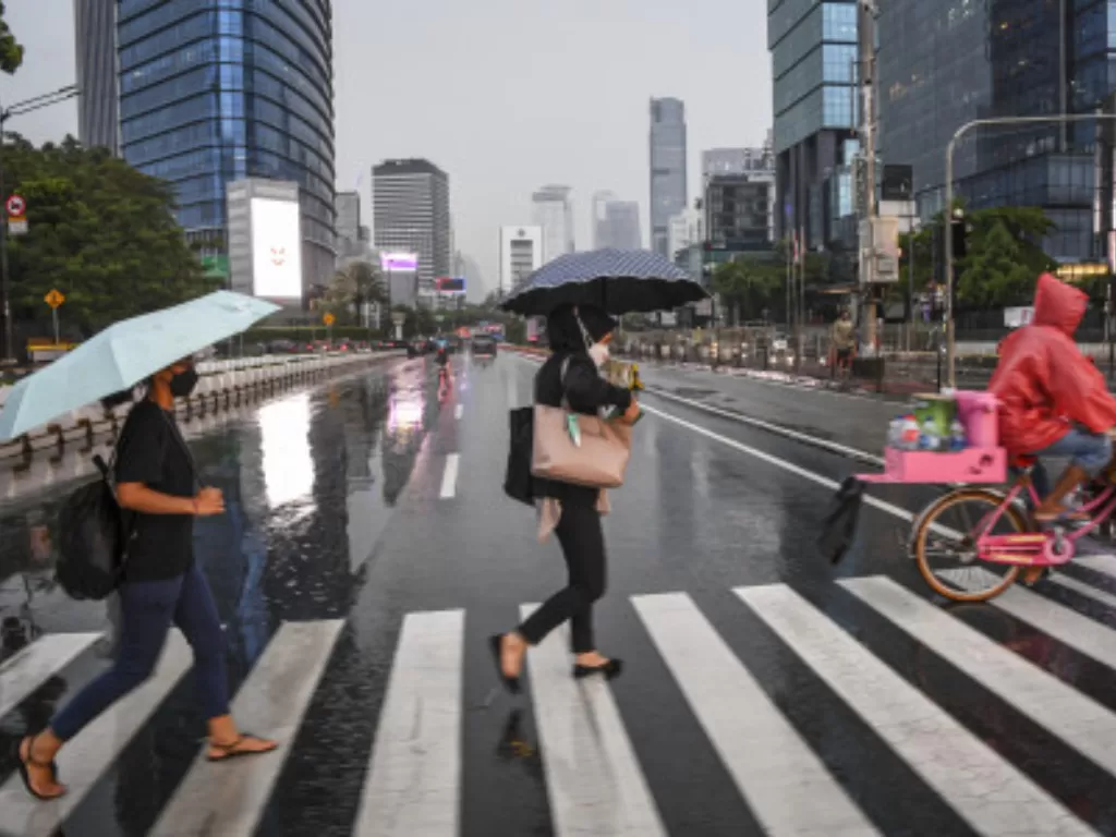 Ilustrasi warga menggunakan payung saat hujan di kawasan Jalan Jenderal Sudirman, Jakarta. (ANTARA FOTO/M Risyal Hidayat)