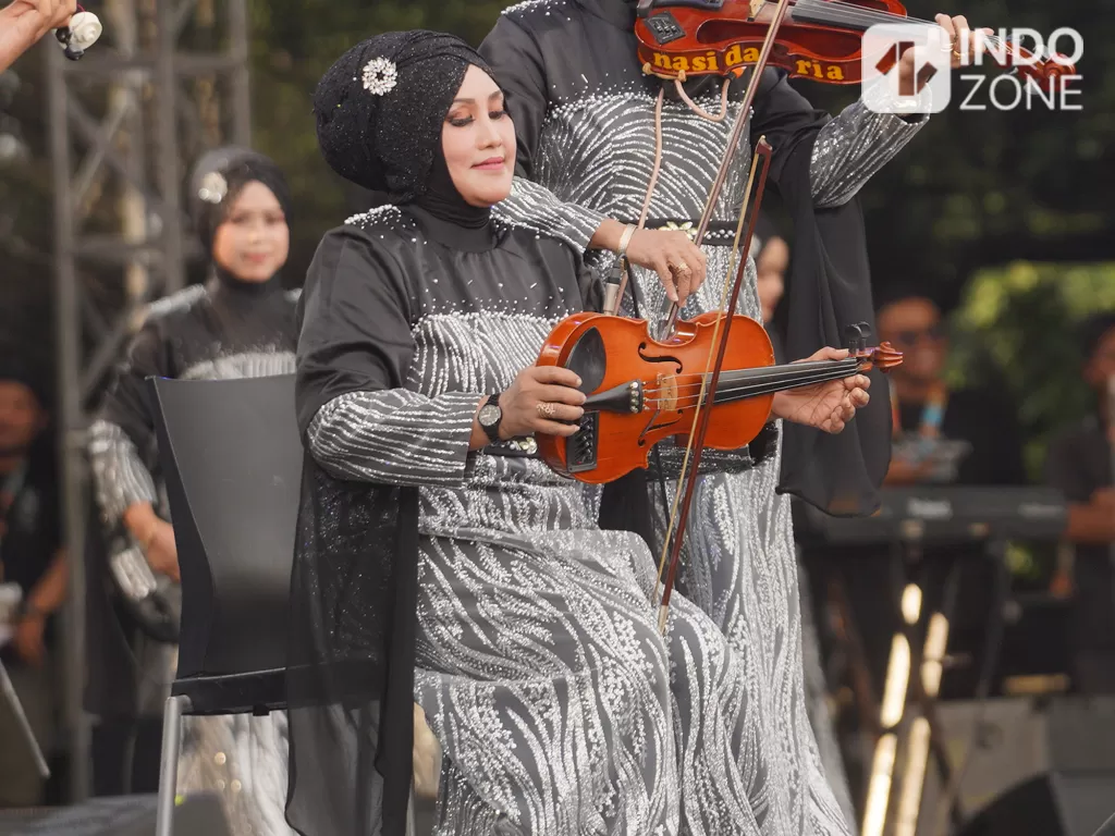 Pemain biola Nasida Ria main dengan gaya unik pada acara Synchronize Fest 2022 di Gambir Expo, Kemayoran, Jakarta Pusat, Minggu (9/10/2022). (INDOZONE/M. Rio Fani)
