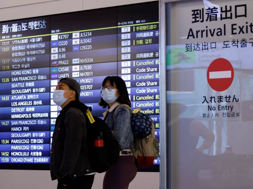 Wisatawan asing berjalan kaki setibanya di Bandara Internasional Haneda, pada hari pertama Jepang membuka pintunya bagi wisatawan setelah menutupnya selama dua setengah tahun karena pembatasan perjalanan yang dipicu oleh wabah penyakit virus corona (COVID
