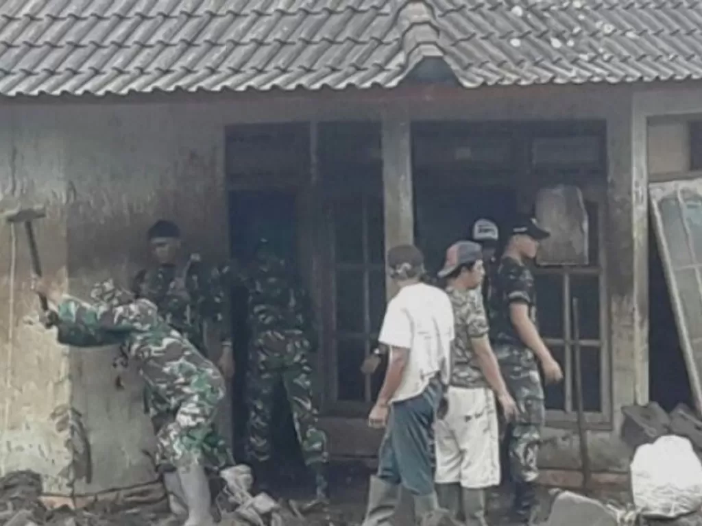 TNI membantu membersihkan rumah-rumah warga dari bekas banjir bandang, Senin, 17 Oktober 2022. (VOA Indonesia)