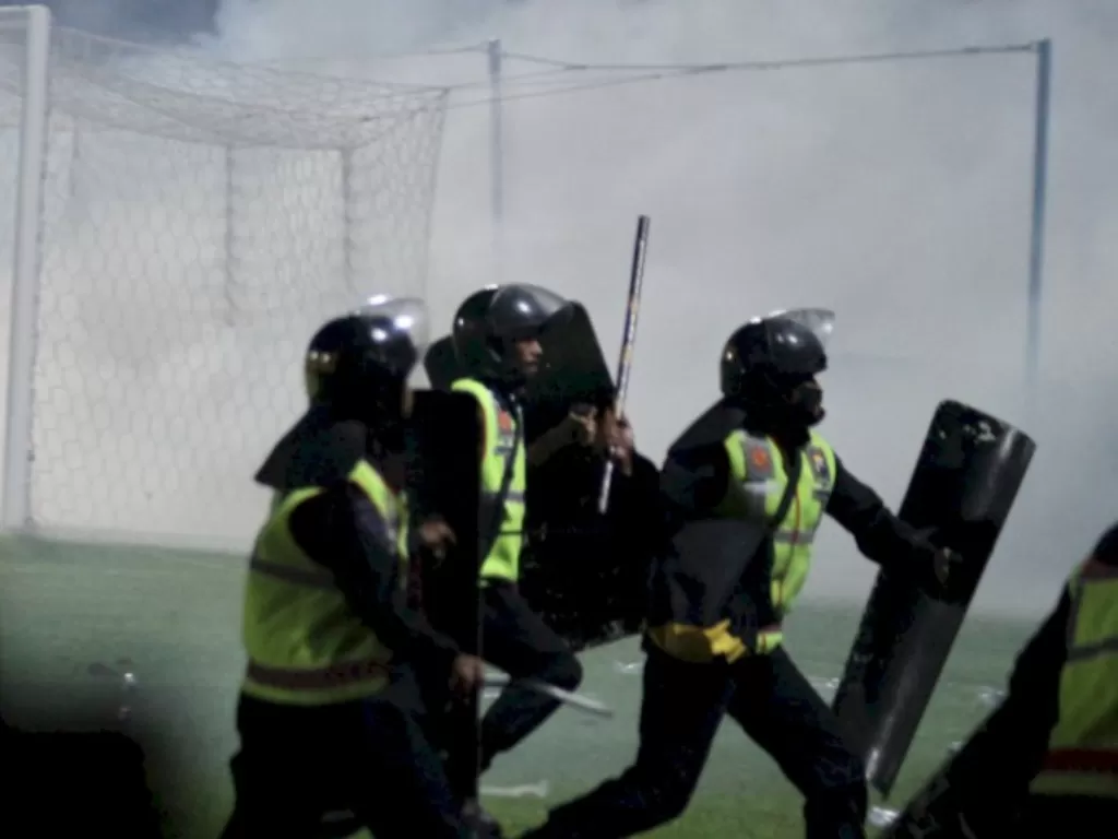 Aparat keamanan berusaha menghalau suporter yang masuk ke lapangan usai pertandingan Arema melawan Persebaya di Stadion Kanjuruhan. (ANTARA/Ari Bowo Sucipto)