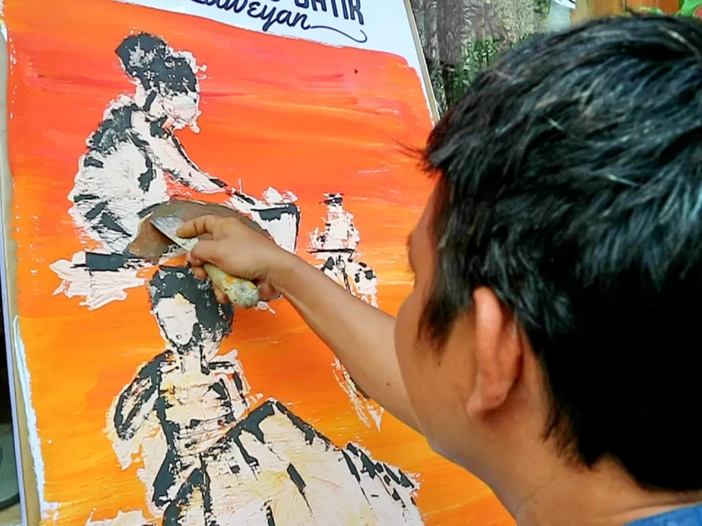 Seniman Solo melukis pakai alat pengerut cat tembok. (Z Creators/Is Ariyanto)
