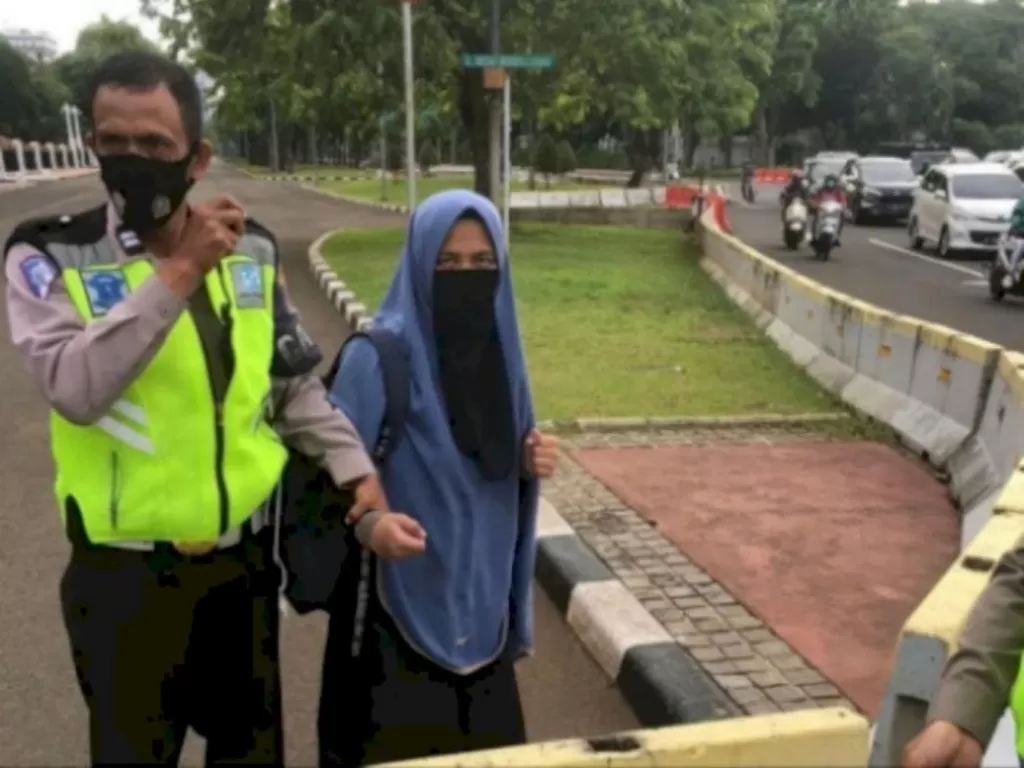 Polisi mengamankan wanita bercadar yang menodongkan pistol ke Paspampres Istana Negara. (Instagram/@lovers_polri) News