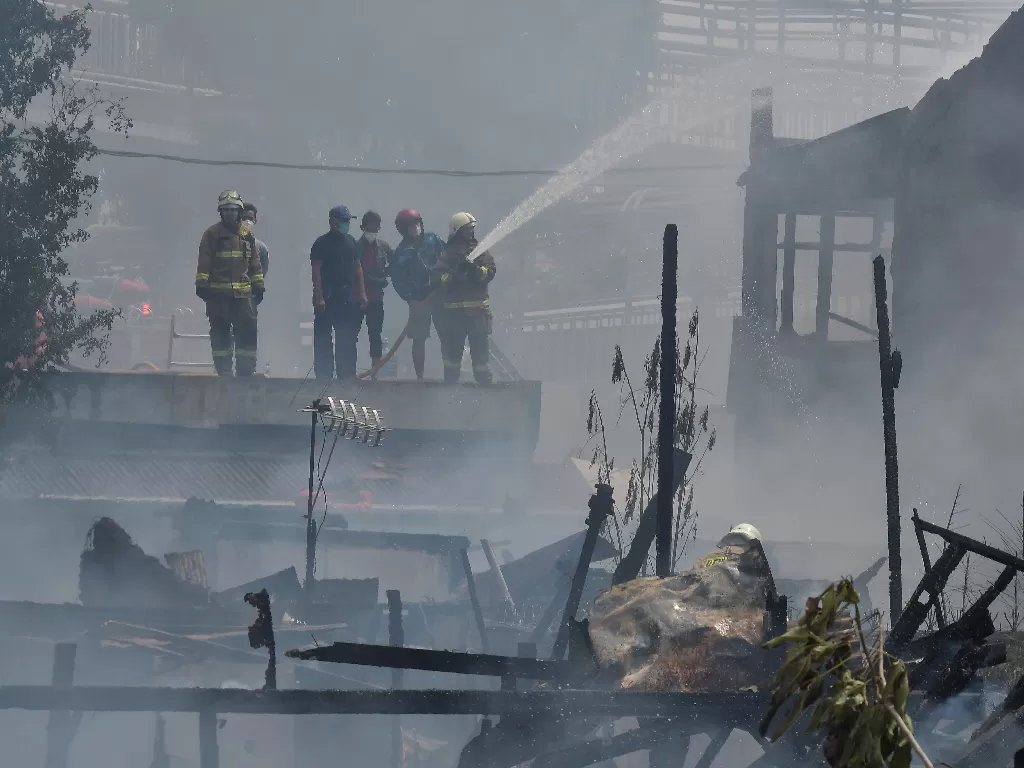 Sejumlah petugas melakukan pendinginan saat kebakaran rumah padat penduduk di Jalan Kebayoran Lama, Jakarta, Minggu (30/10/2022). (ANTARA FOTO/ Fakhri Hermansyah/aww).