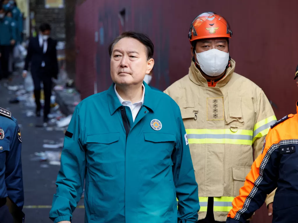 Presiden Korea Selatan Yoon Suk-yeol berjalan di lokasi kejadian tragedi Itaewon perayaan Halloween di Seoul yang tewaskan ratusan orang pada Sabtu (29/10/2022). (REUTERS/ Heo Ran)