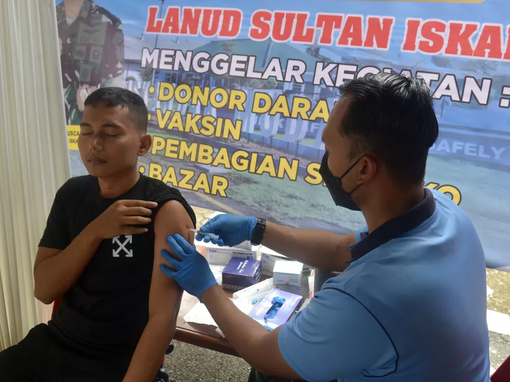 Petugas kesehatan TNI-AU menyuntikan vaksin COVID-19 kepada warga saat berlangsung kegiatan bhakti sosial dan bantuan sosial di Pangkalan Udara Sultan Iskandar Muda (Lanud) Blang bintang, Kabupaten Aceh Besar, Aceh, Sabtu (15/10/2022). (ANTARA/Ampelsa)