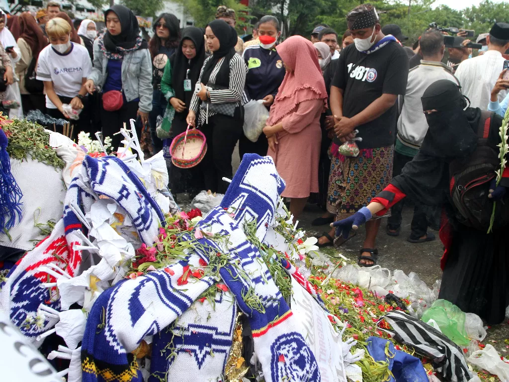 Sejumlah anggota komunitas lintas agama menaburkan bunga usai doa bersama di tugu singa Stadion Kanjuruhan, Malang, Jawa Timur, Jumat (7/10/2022). (ANTARA/Ari Bowo Sucipto)