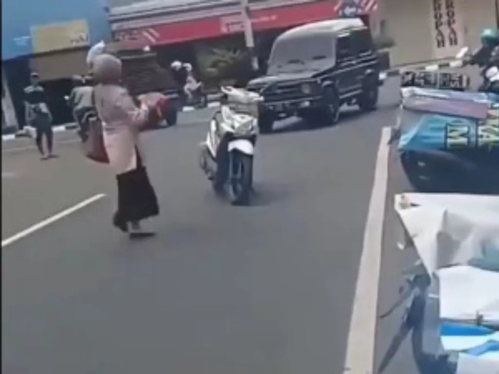 Seorang ibu parkir motor  di tengah jalan. (Twitter/@sopir_idiot)